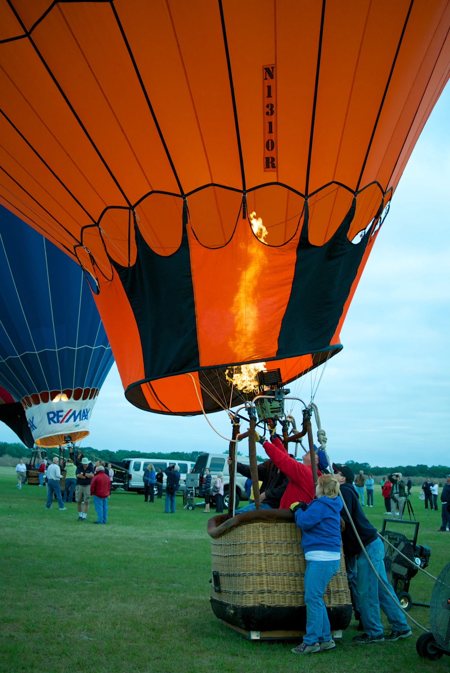 people on an air balloon with one person fixing it