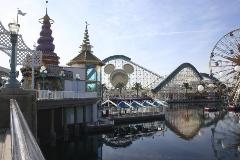 a ferris wheel at a theme park with buildings and a water