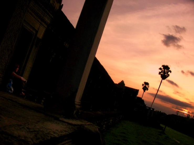 a clock tower is silhouetted against the sunset