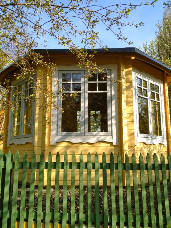 the back of a small yellow cabin with a window