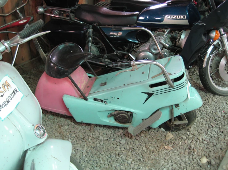 an old motorcycle with a broken seat and some scooters
