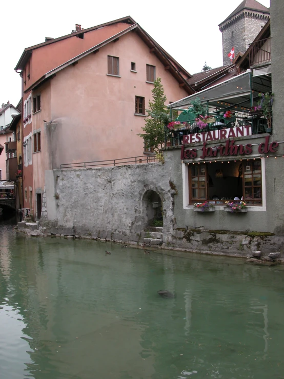 a river that has some people sitting outside the windows