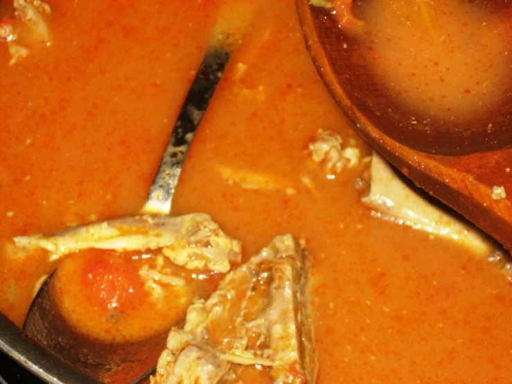 a bowl full of soup with spoons and another one in it