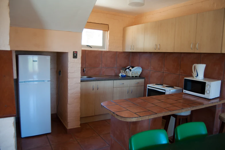 a kitchen filled with appliances and tiled floors