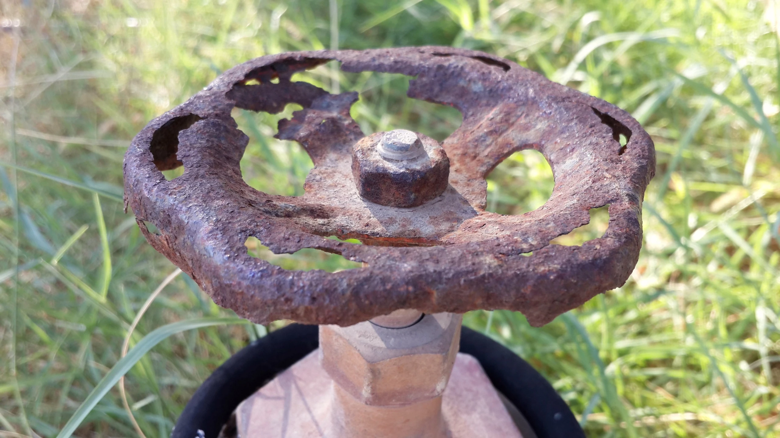 an old metal object sitting on top of a wooden table