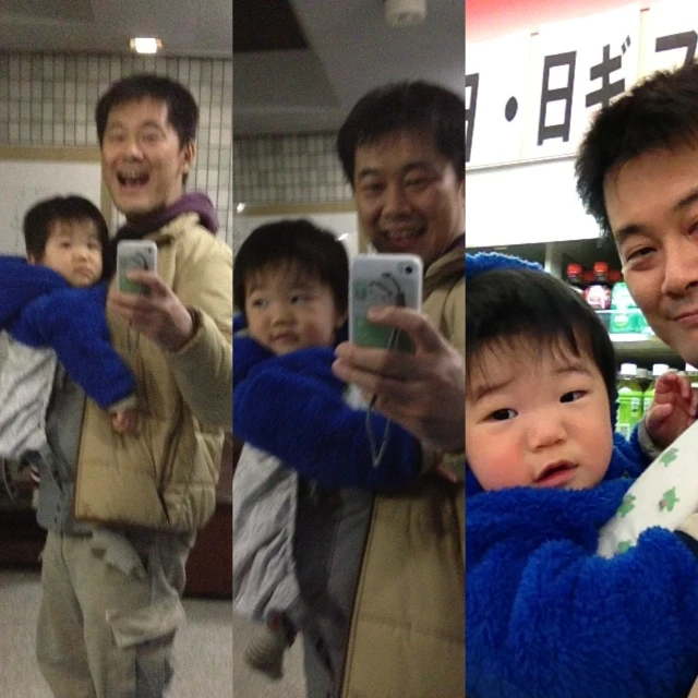 several people taking pictures with phones while holding up a baby