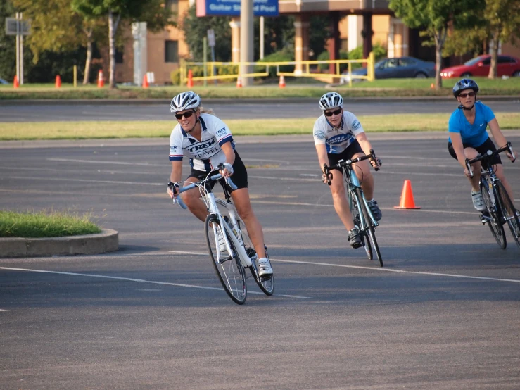 two bikers racing next to each other near a cone