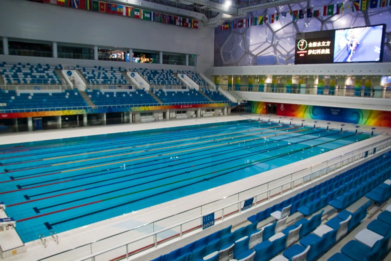 an indoor pool is shown with many blue seats