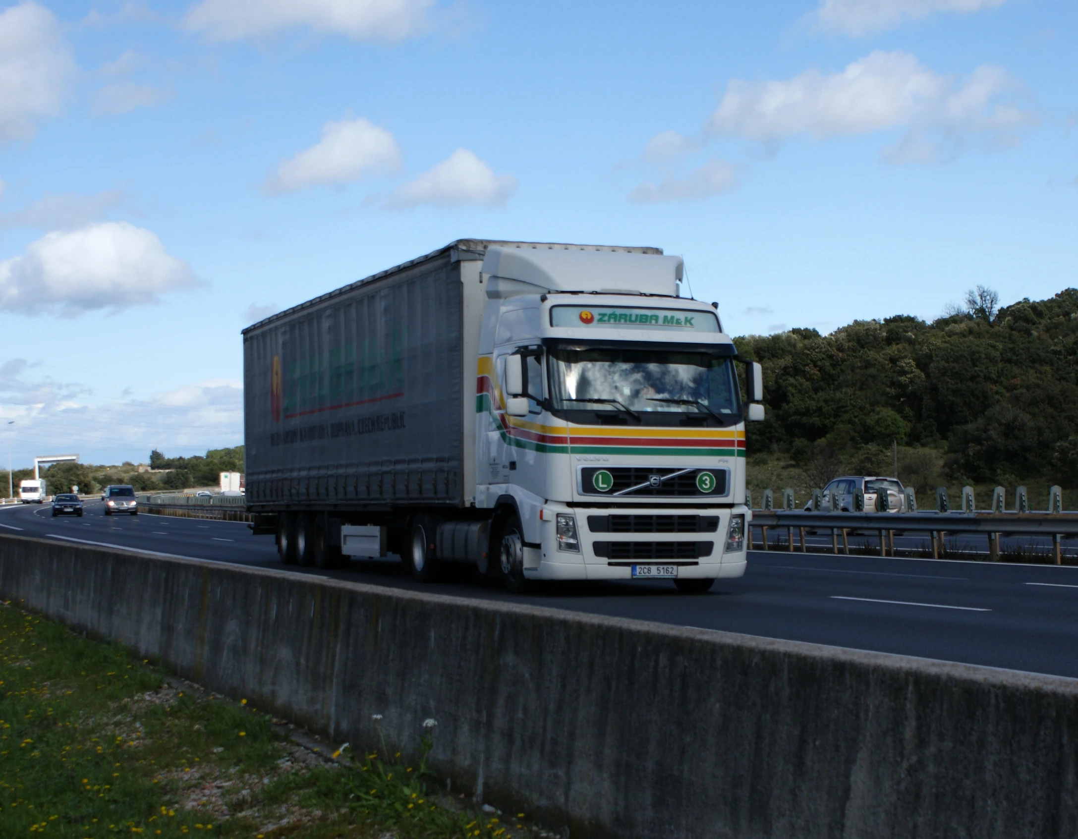 the truck is driving down the highway near other cars