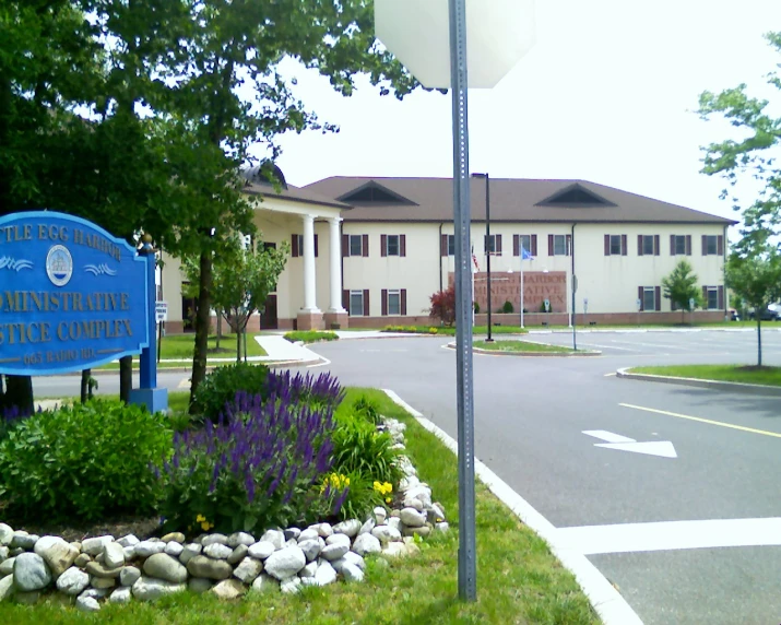 a large building with a blue sign and landscaping