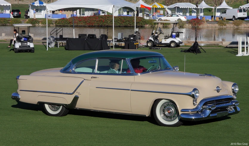 old cars sitting on a grassy area at an outdoor event