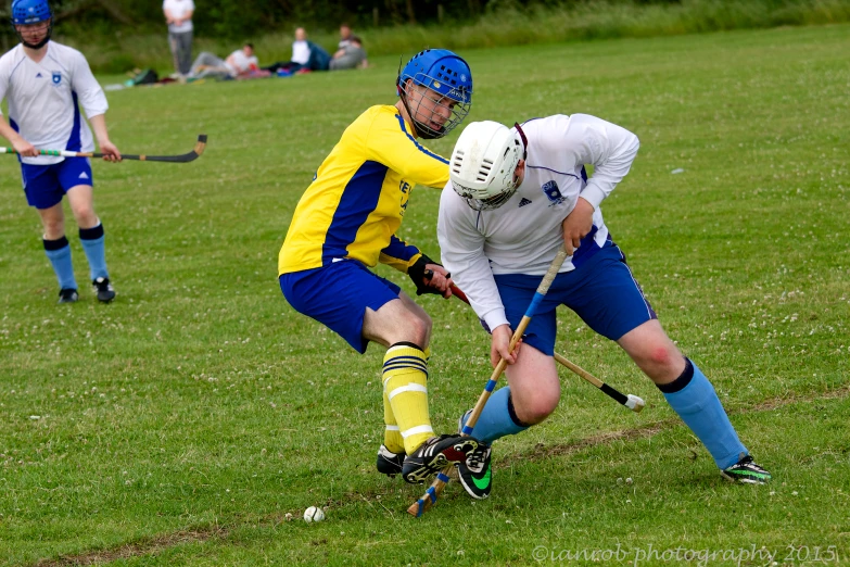 a couple of men playing a game of lacrosse