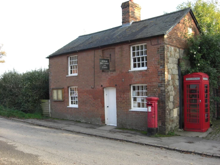 an old brick house has two red phone booths