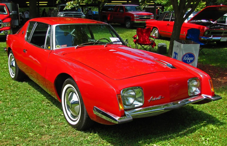 a red sports car is parked on grass