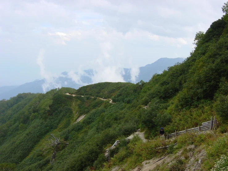 people are hiking up a trail in the mountains