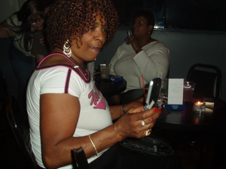 a woman looking at her phone while another woman looks on