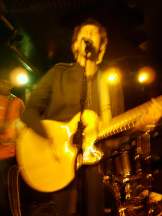 man in black shirt playing a guitar and singing