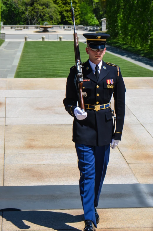 a soldier in uniform walking and holding a rifle