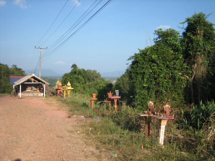a dirt road with various objects on the side