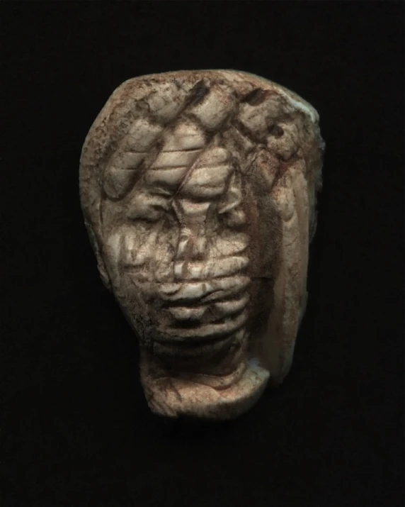 a stone sculpture sitting against a black background