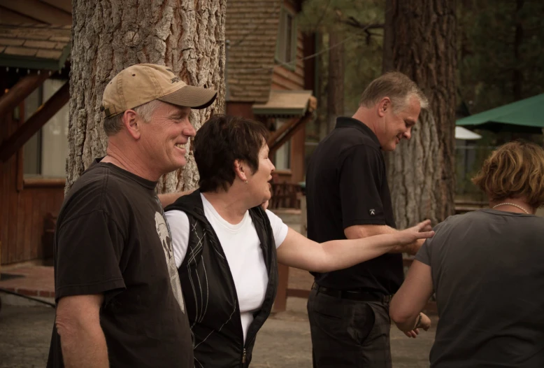 a group of people standing next to a tree