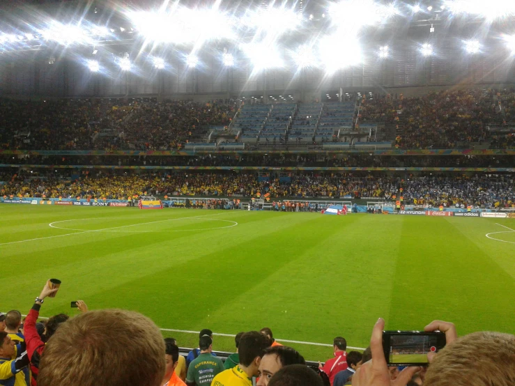 a group of people holding their cell phones up near a stadium