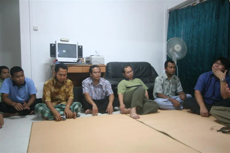 five men sit together and talk in a room