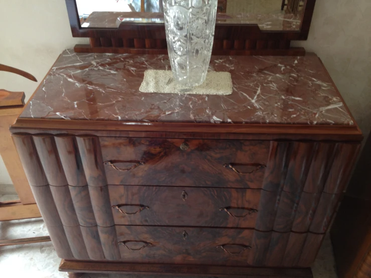 a marbled dresser and mirror with a wooden frame