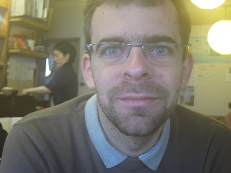 a man wearing glasses looks at the camera