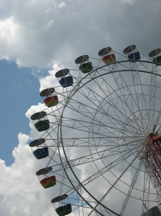 a carnival rides in the sky with a cloudy background