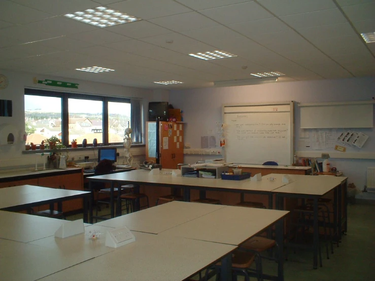 this classroom is empty and has desks on both sides of the room