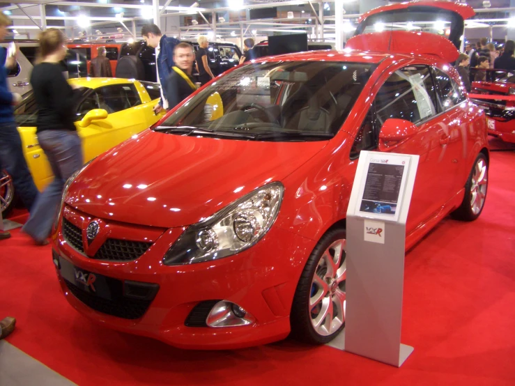 a car displayed at an auto show that is red