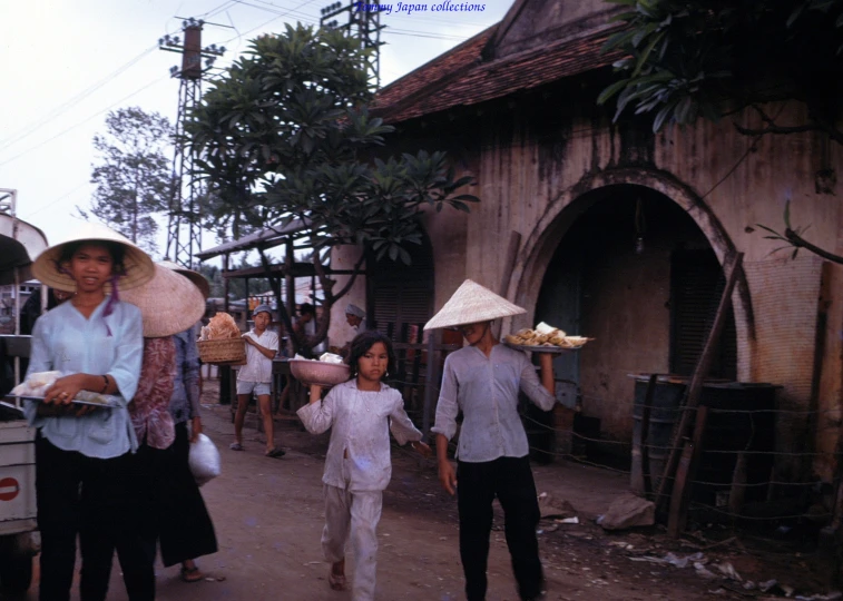 a group of people holding umbrellas walking down a road
