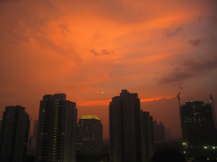 many buildings in the background with a red sky