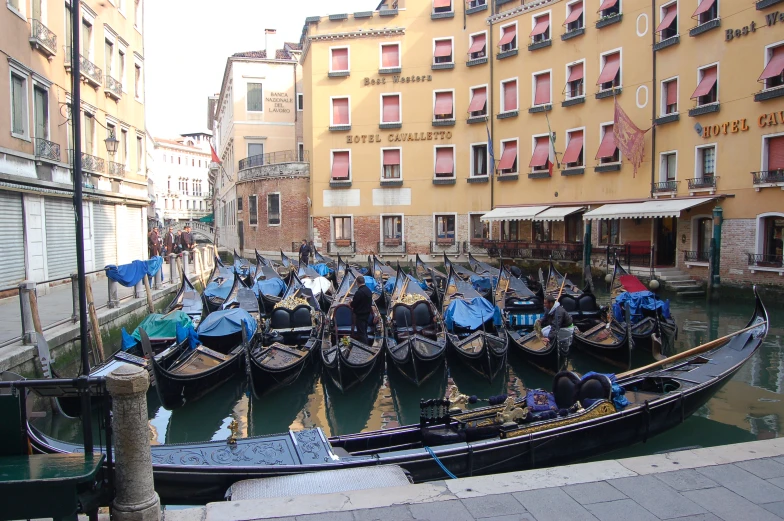a number of small boats in water near buildings