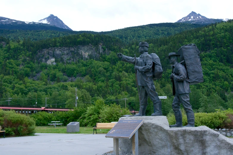 a statue of two soldiers is in the middle of a park