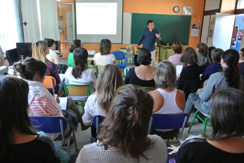 several people watching a man giving a presentation