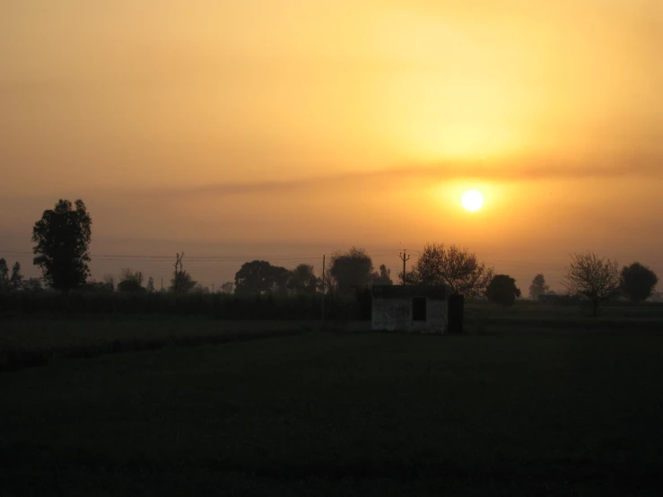 a very pretty sunset with a field next to it