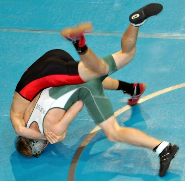 two players wrestling on a sports court during a game