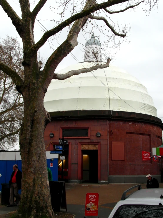 people are walking in front of a big white dome