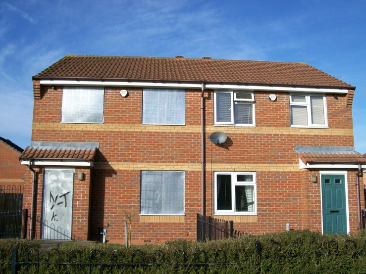 a brick building has three windows in front of it