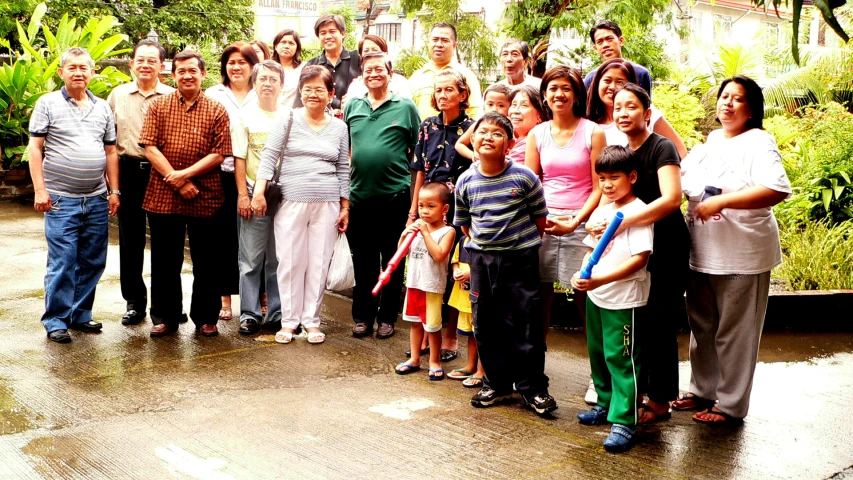 a group of people standing next to each other in front of a jungle