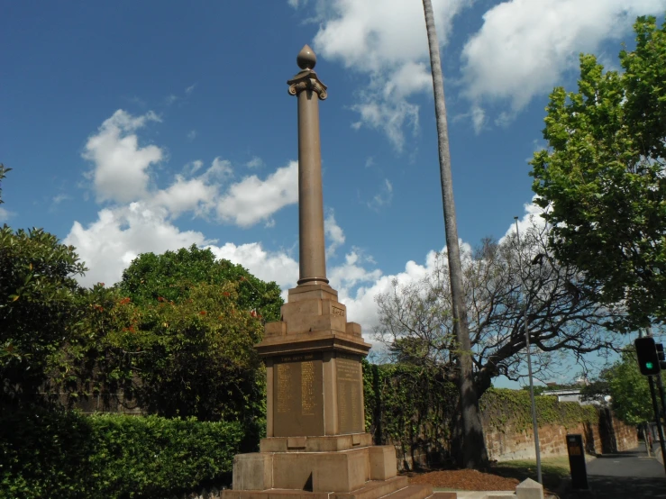 a tall tall pillar sitting in the middle of a park