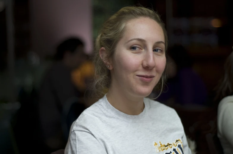 a woman in a white shirt is posing for the camera