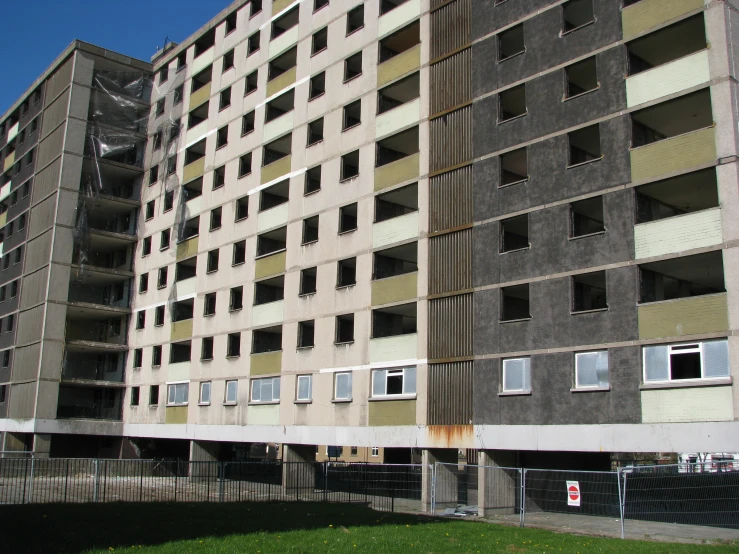 two concrete building with broken windows are facing each other