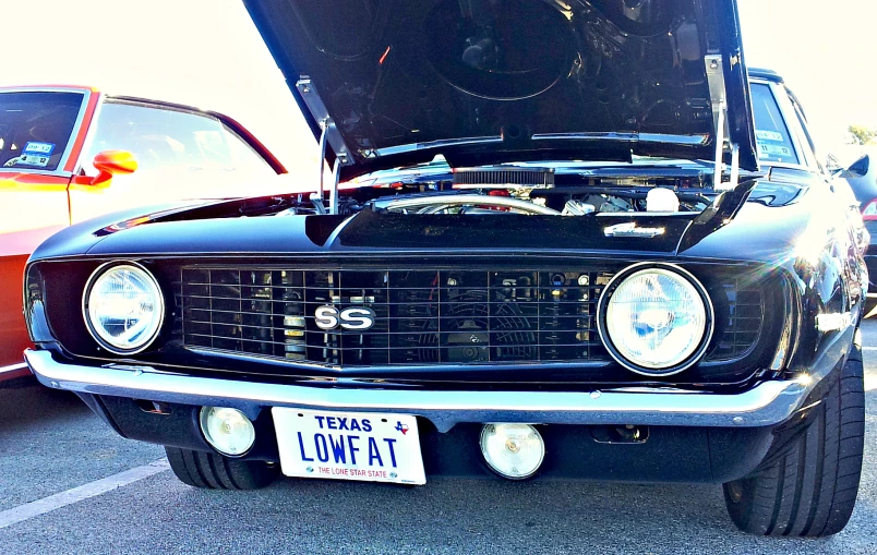 a black and white classic car with orange ribbons