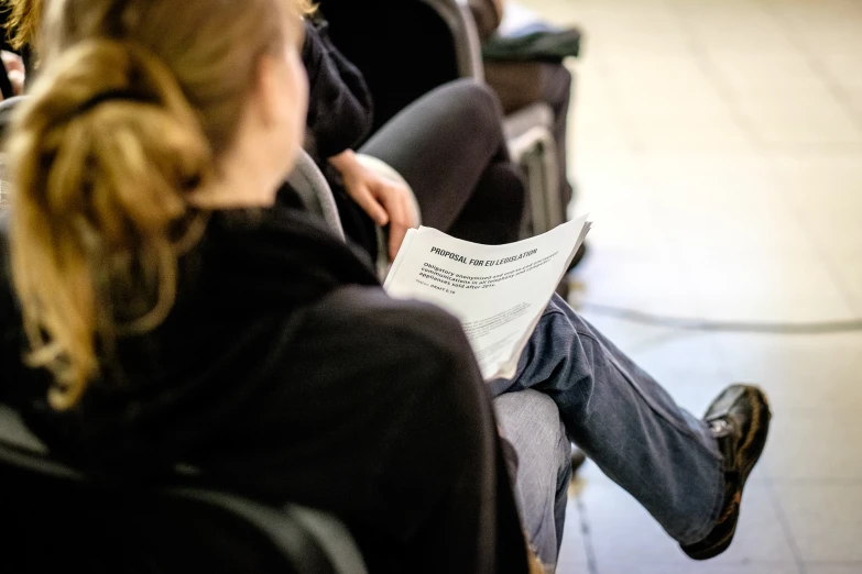 the women is sitting down holding paper