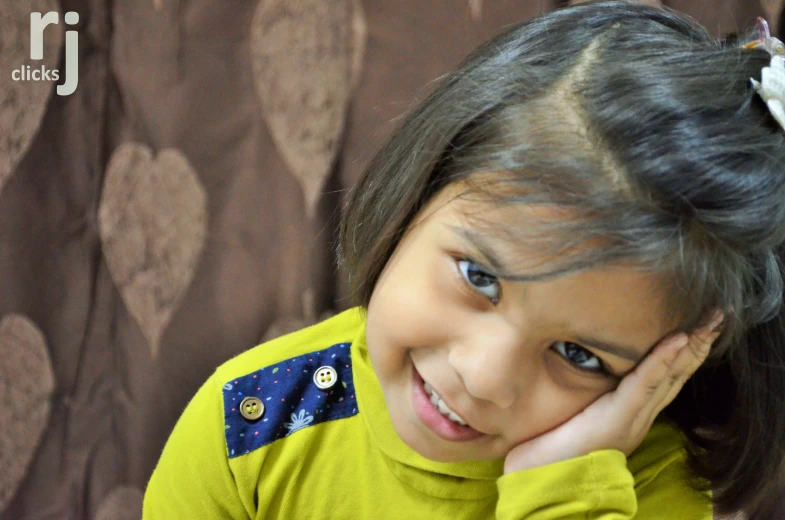 a little girl smiling and looking at the camera