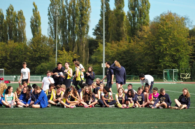 a group of people sit in a field together