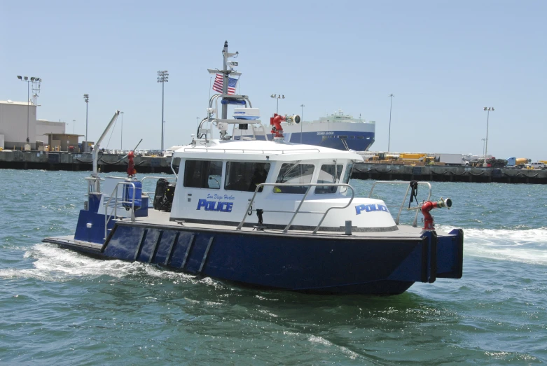 a blue and white boat in the ocean near a dock